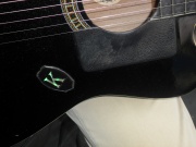 Detalhe da letra "K" em seu violão.
